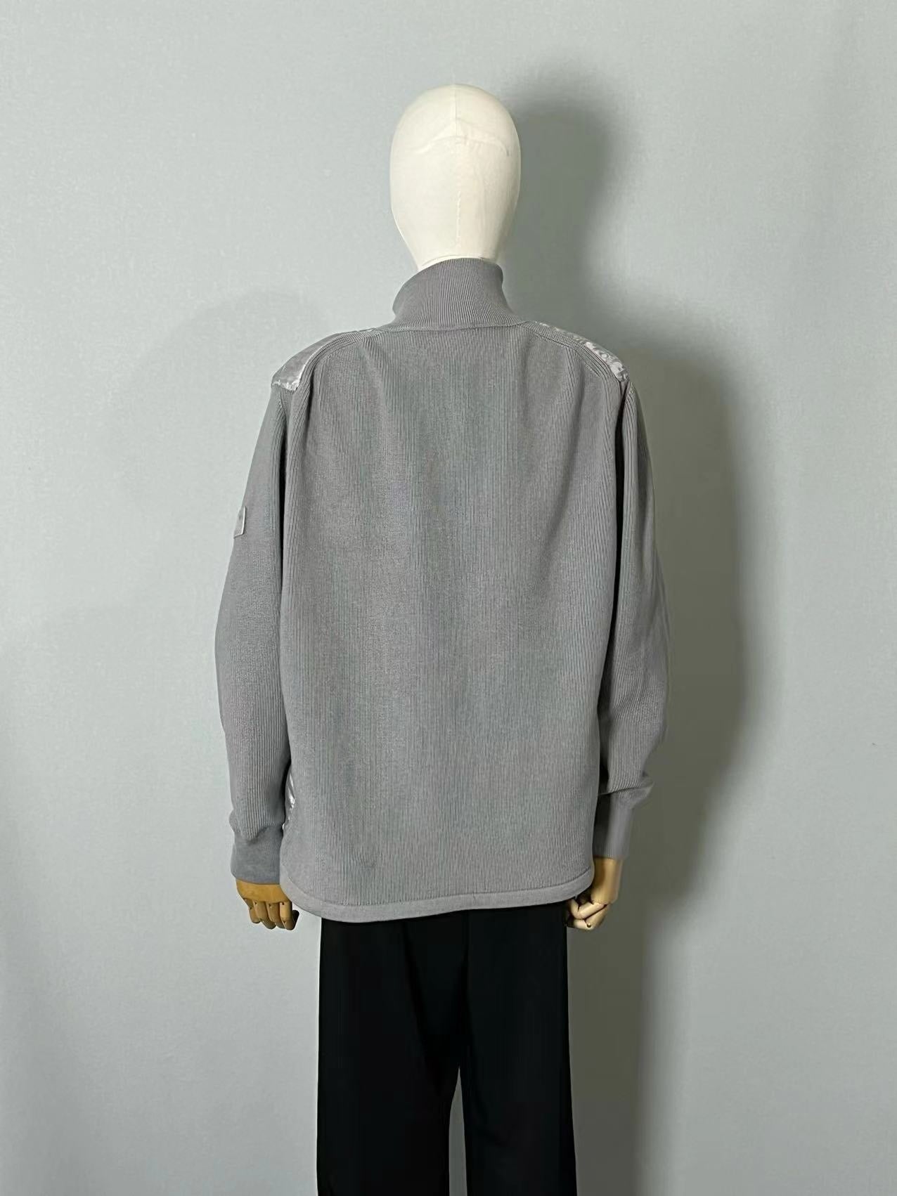 Schwarze, graue, blaue und weiße Jacke